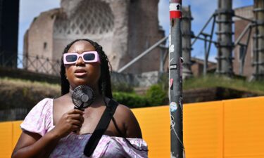 A woman cools off with a mini fan in Rome