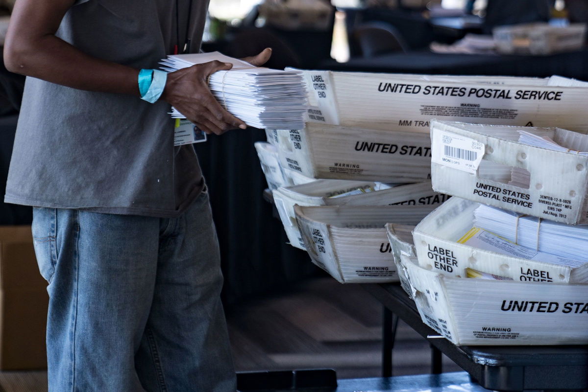 <i>Megan Varner/Getty Images</i><br/>An election worker processes absentee ballots at State Farm Arena on November 2