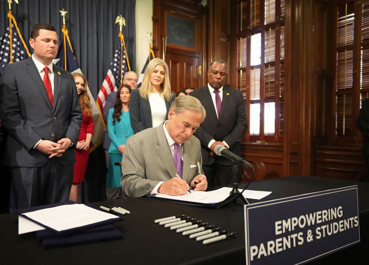 <i>Jay Janner/Austin American-Statesman/AP</i><br/>Texas Gov. Greg Abbott signs into law HB 900