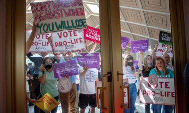 Demonstrators hold signs as North Carolina Republican lawmakers hold a vote to override Democratic Governor Roy Cooper's veto of a bill that would ban most abortions in the state after 12 weeks