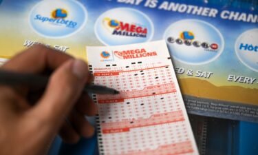 A person plays Mega millions lottery at a gas station as giant Powerball and Mega Millions jackpots grow more than $1B combined