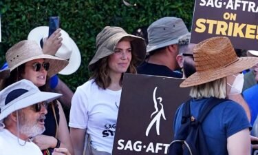 (From left) Katie Lowes and Mandy Moore walk the picket line in support of the SAG-AFTRA and WGA strike on in Los Angeles on July 18.