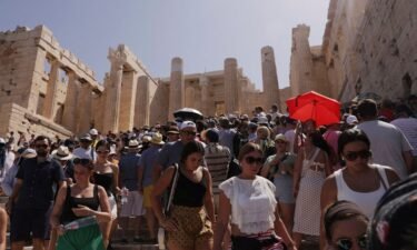 Visitors walk in front of the Acropolis' Propylaea