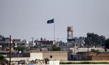 An ISIS flag flies in the northern Syrian town of Tel Abyad as seen from the Turkish border town of Akcakale on June 15