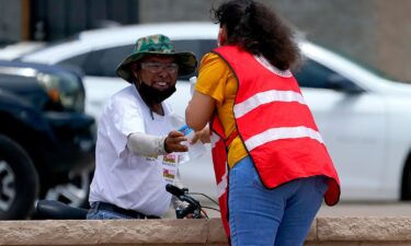 A Salvation Army volunteer gives water to a man at their Valley Heat Relief Station on July 11 in Phoenix.