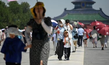 Tourists visit the Temple of Heaven on a hot day in Beijing on June 30.