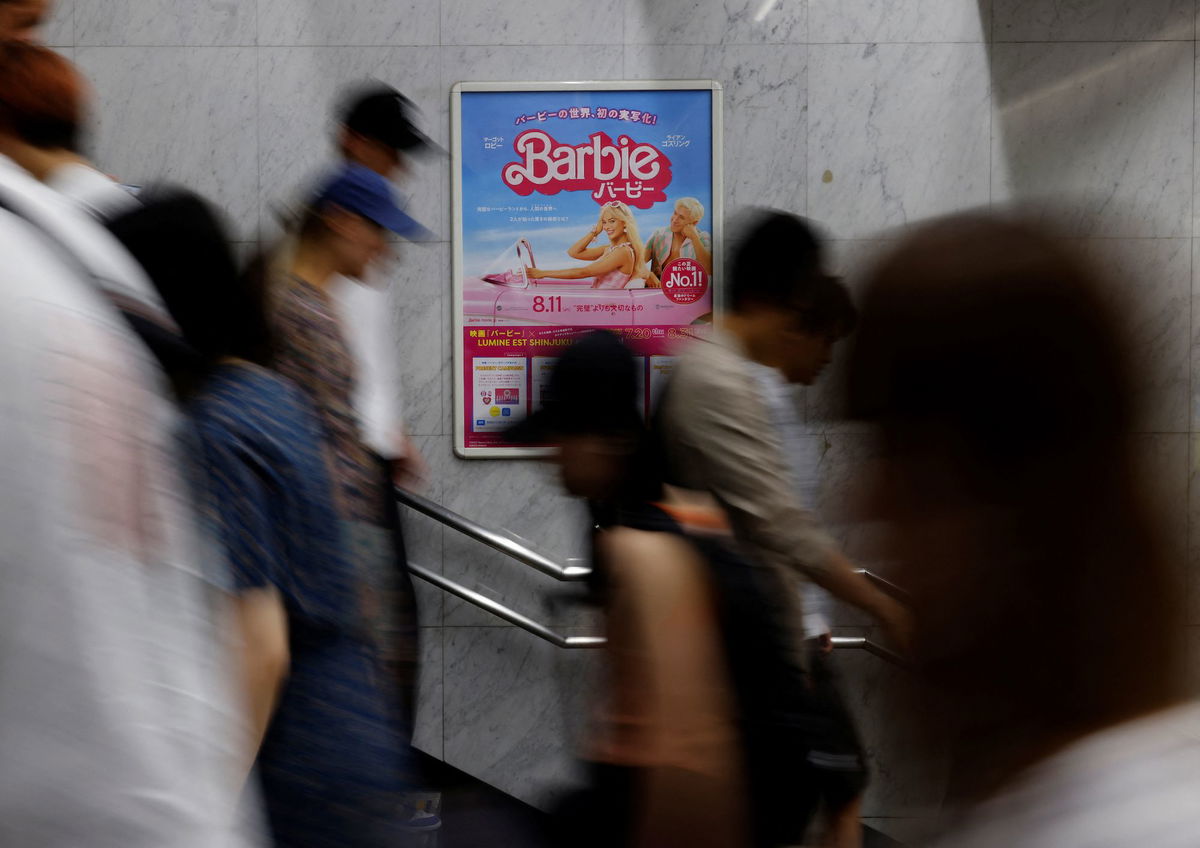 People walk past a promotional poster of film 