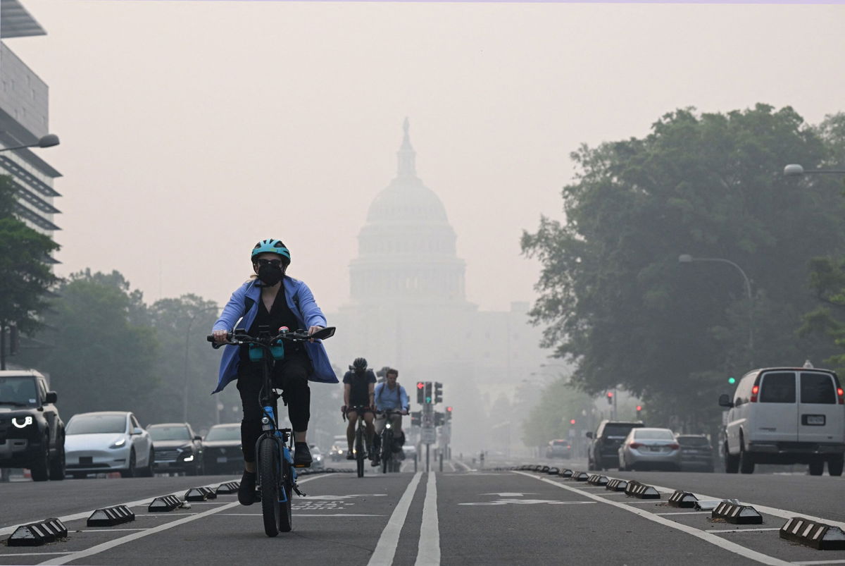A cyclist rides under a blanket of haze partially obscuring the US Capitol in Washington, DC, on June 8.	