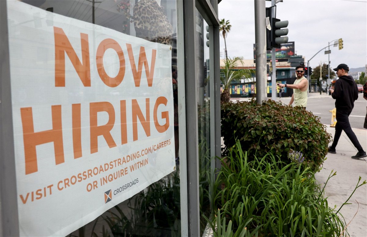 Job openings fell for the third consecutive month. Displayed is a 'Now Hiring' sign outside a resale clothing shop on June 2, in Los Angeles.
