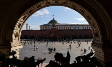 People walk across Red Square near the Mausoleum of Soviet state founder Vladimir Lenin and the Kremlin Wall in central Moscow