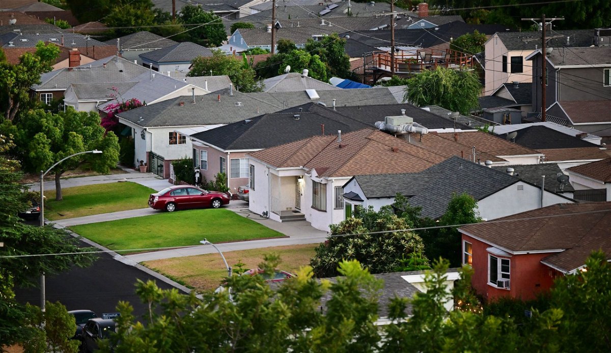 Green grass lawns seen in front of homes in a Los Angeles, California neighborhood on July 5, 2022. US pending home sales ticked up in July by 0.9%, rising for the second month in a row despite elevated prices and rising mortgage rates, according to a report released by the National Association of Realtors.