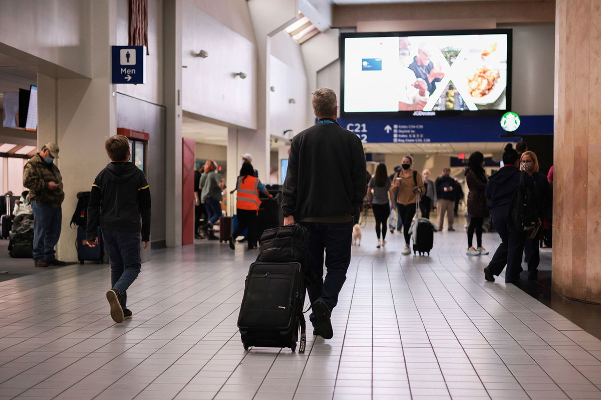 People walk through the Dallas/Fort Worth International Airport in November 2021 in Dallas, Texas.