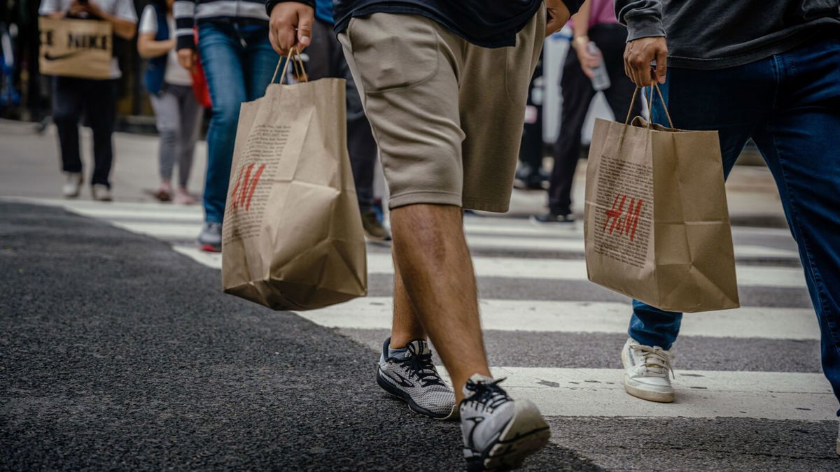 Shoppers carry retail bags along the Magnificent Mile shopping district in Chicago on Aug. 15. US retail sales rose in July by more than forecast, suggesting consumers still have the wherewithal to sustain the economic expansion.