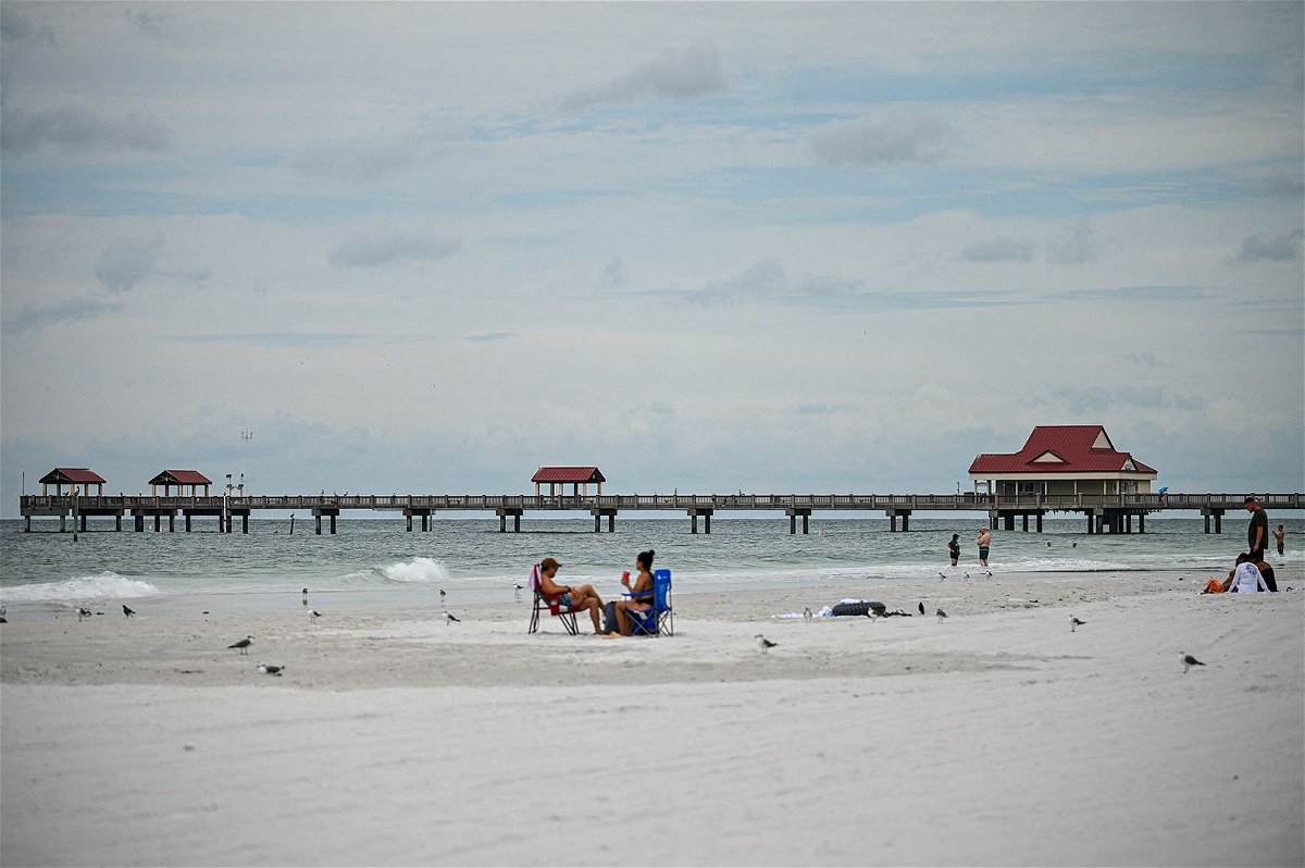 People sit on the beach in Tampa on August 29 as the storm approached Florida. Hurricane Idalia made landfall farther north the next day.