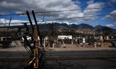 Downed power lines block a road outside a burnt home in the aftermath of a wildfire in Lahaina