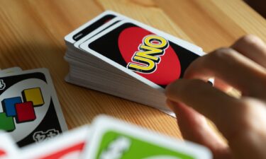 A person is seen playing UNO card game.