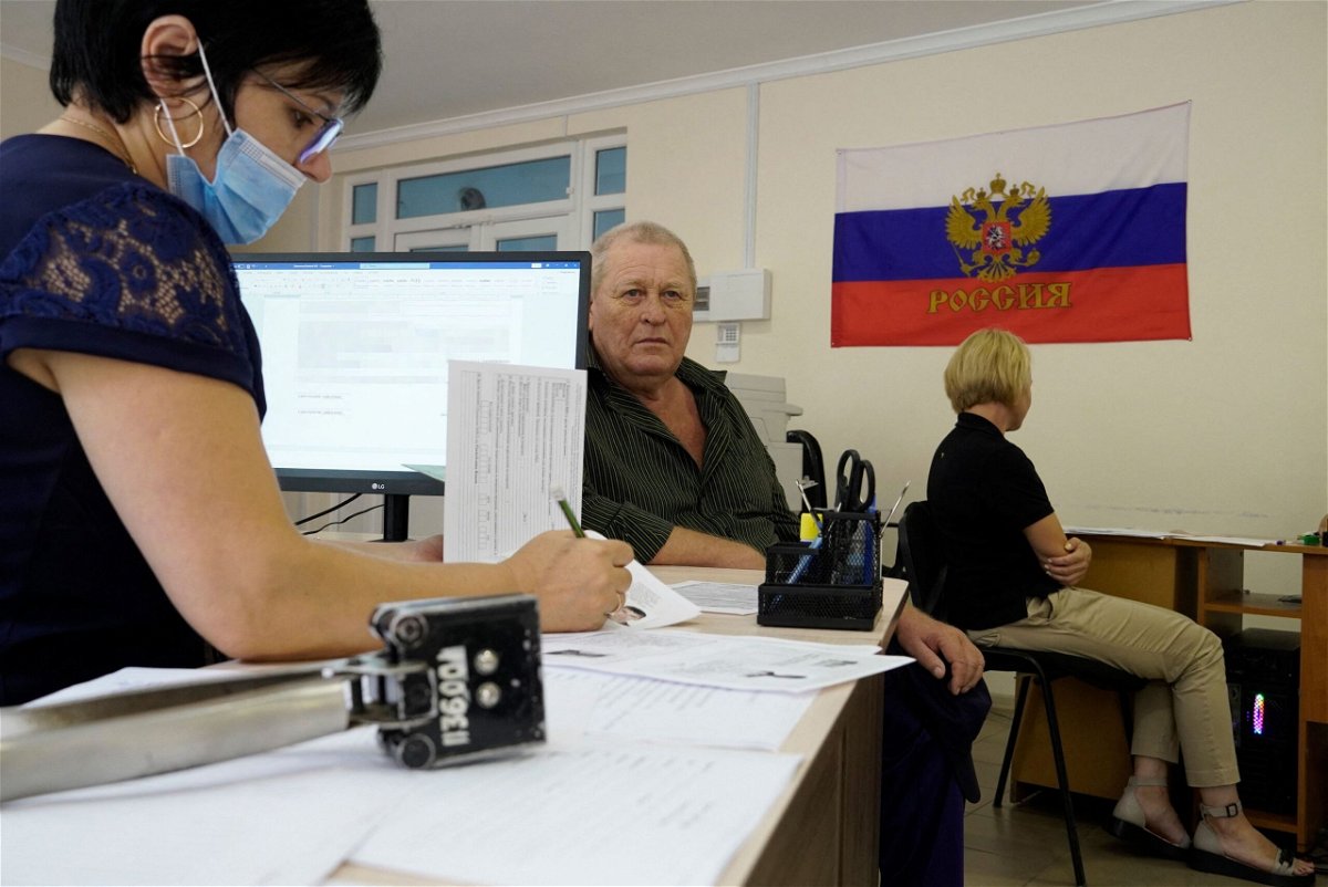 <i>Stringer/AFP/Getty Images</i><br/>A man fills document to apply for new Russian passport at a centre in Melitopol.
