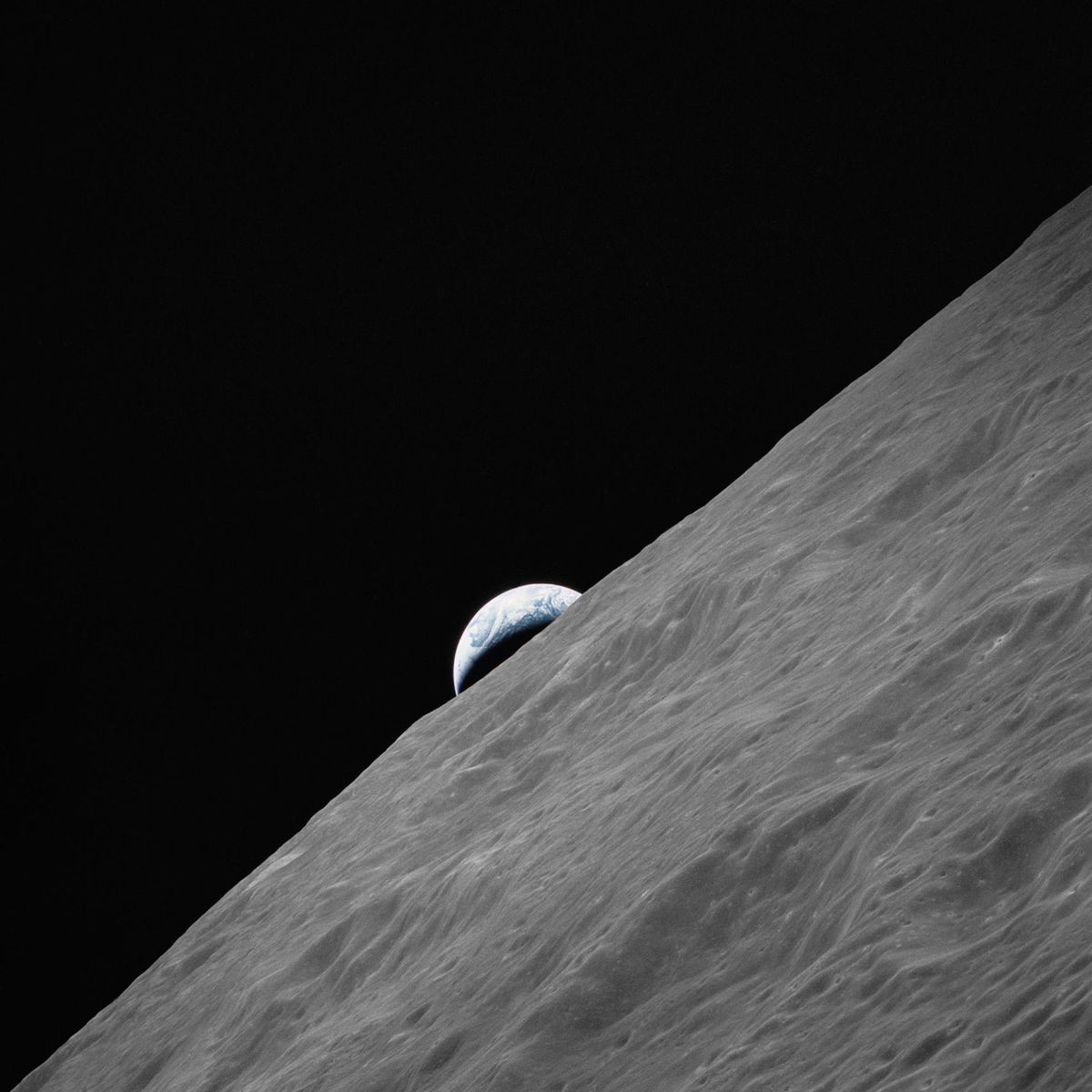 Earth rises above the lunar horizon in this photo taken from NASA's Apollo 17 spacecraft while in orbit during the Apollo program's final lunar landing mission.