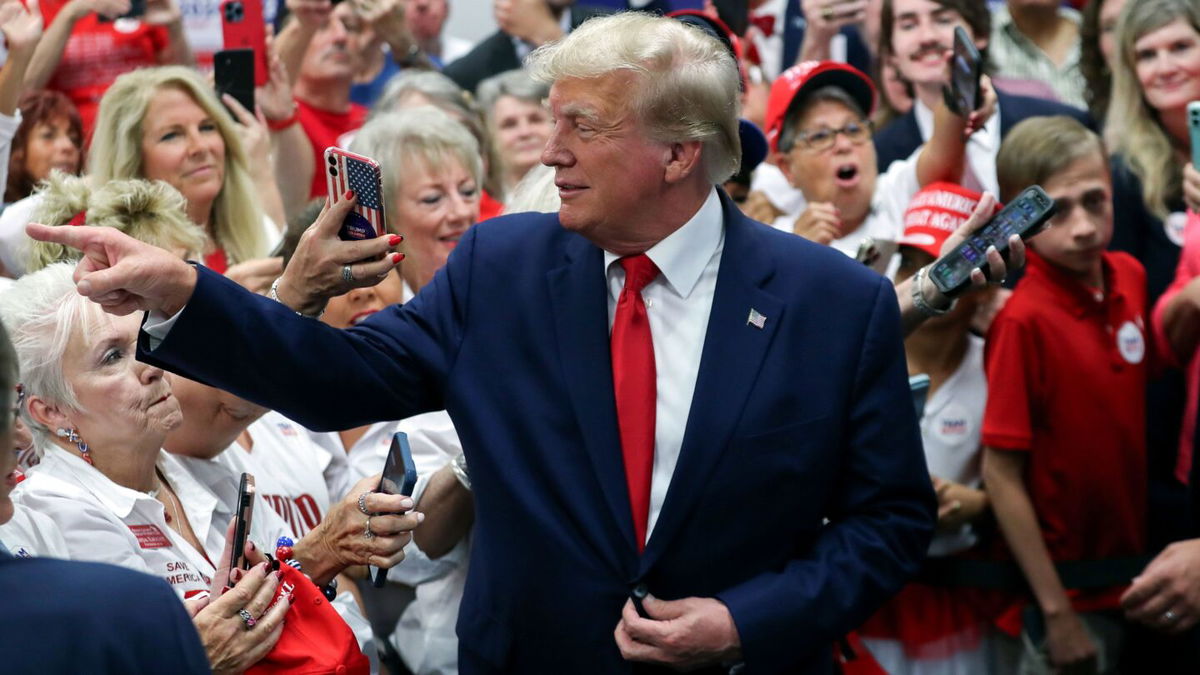 <i>Artie Walker Jr./AP</i><br/>Former President Donald Trump points to a supporter and smiles while visiting a Trump 2024 campaign office in Summerville