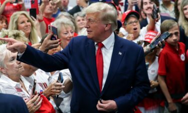 Former President Donald Trump points to a supporter and smiles while visiting a Trump 2024 campaign office in Summerville