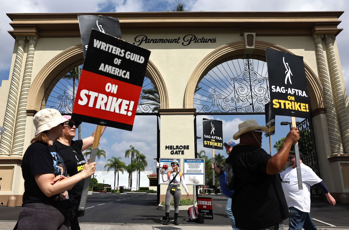 Strike captain SAG-AFTRA member Cari Ciotti (C) looks on as striking WGA (Writers Guild of America) members picket with striking SAG-AFTRA members outside Paramount Studios on September 18 in Los Angeles, California.