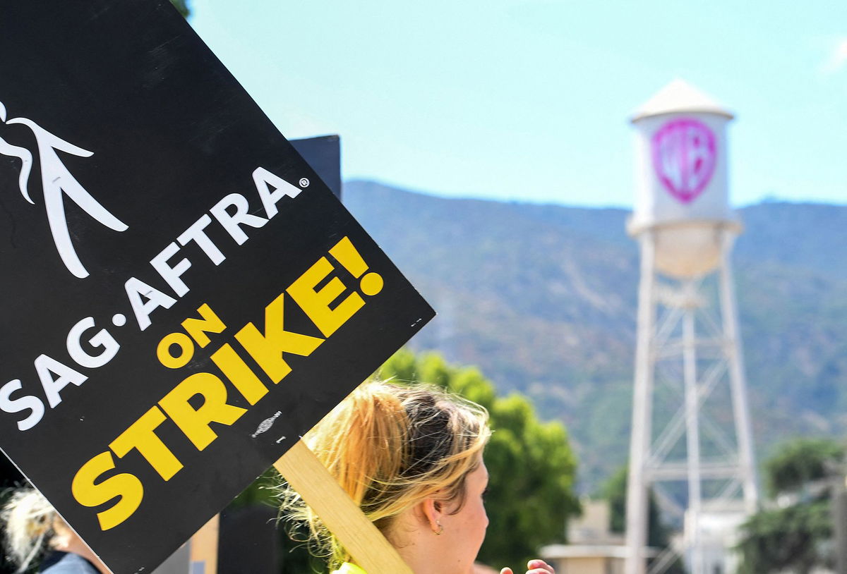 Members of the Writers Guild of America and the Screen Actors Guild walk a picket line outside of Warner Bros Studio in Burbank, California, on July 26.