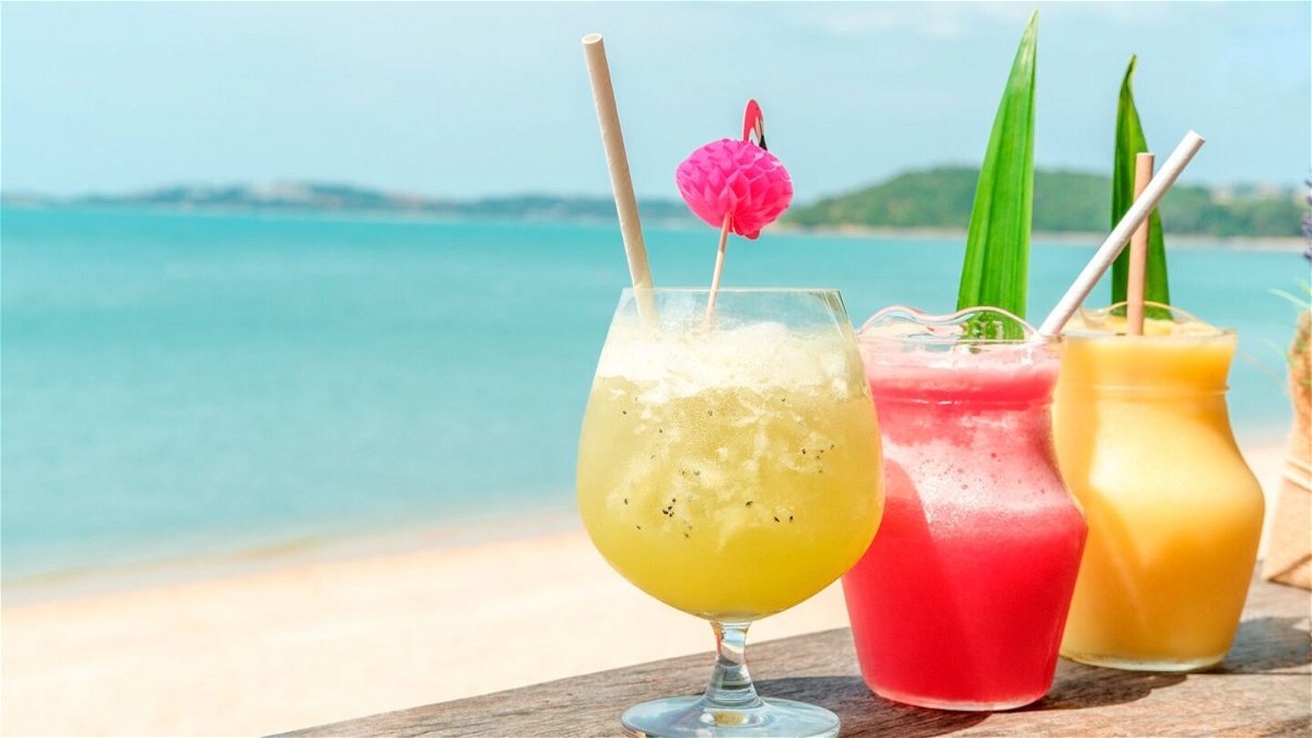 Colorful mocktails are pictured at the beach bar with sea background.