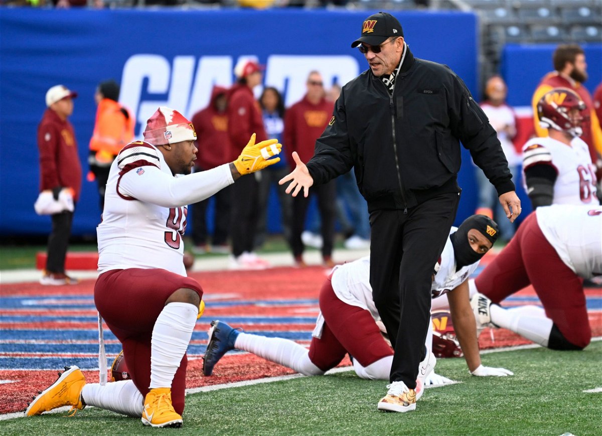 <i>John McDonnell//The Washington Post/Getty Images</i><br/>Commanders defensive tackle Daron Payne (94) shakes hands with Washington Commanders head coach Ron Rivera.