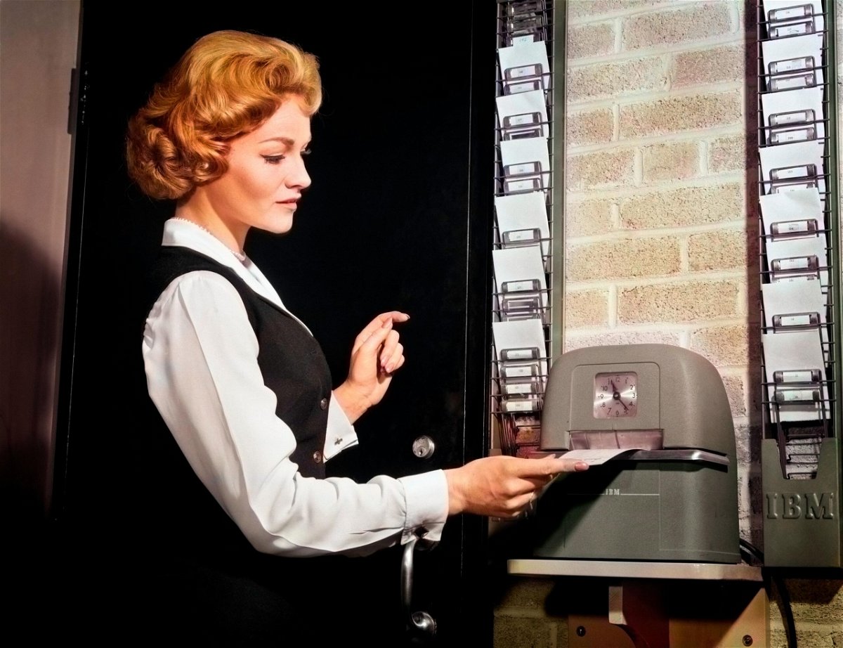 1960s Woman Punching Time Clock At Work photo.