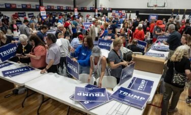 Volunteers put together signs before former President Donald Trump's arrival at a volunteer event in Grimes