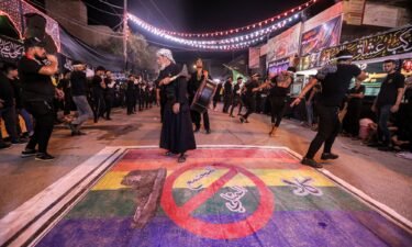 Shiite Muslim devotees self-flagellate over an unfurled banner on the ground depicting the Pride rainbow flag defaced with a boot and the Arabic slogan "no to homosexual society