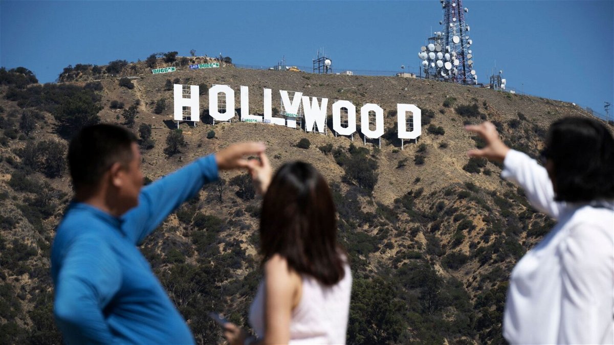 Visitors pose for snapshots in front of the Hollywood sign on September 28, 2022, as it is repainted in preparation for its100th anniversary.