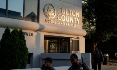 Police officers walk past the Lewis R. Slaton Courthouse.