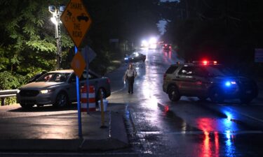 Police monitor a wooded perimeter in the rain during a manhunt for convicted murderer Danelo Cavalcante in Kennett Square