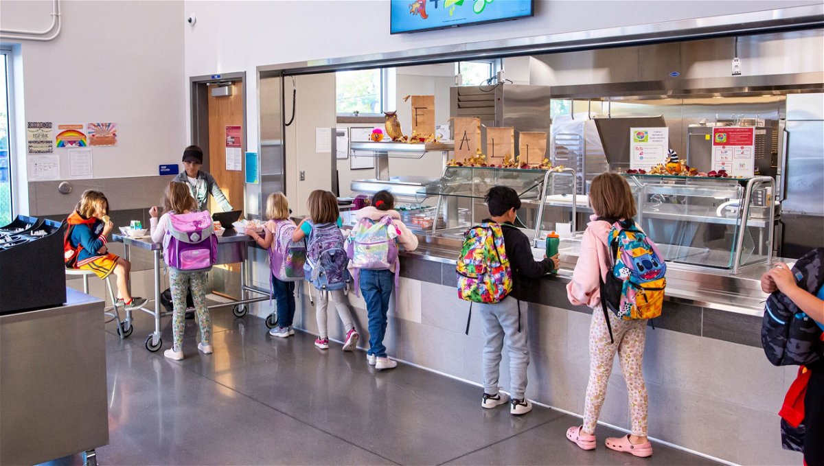 States are stepping in to pay for school meals for all kids. Pictured, are students at Gudy Gaskill Elementary School in Centennial, Colorado picking up their lunch.