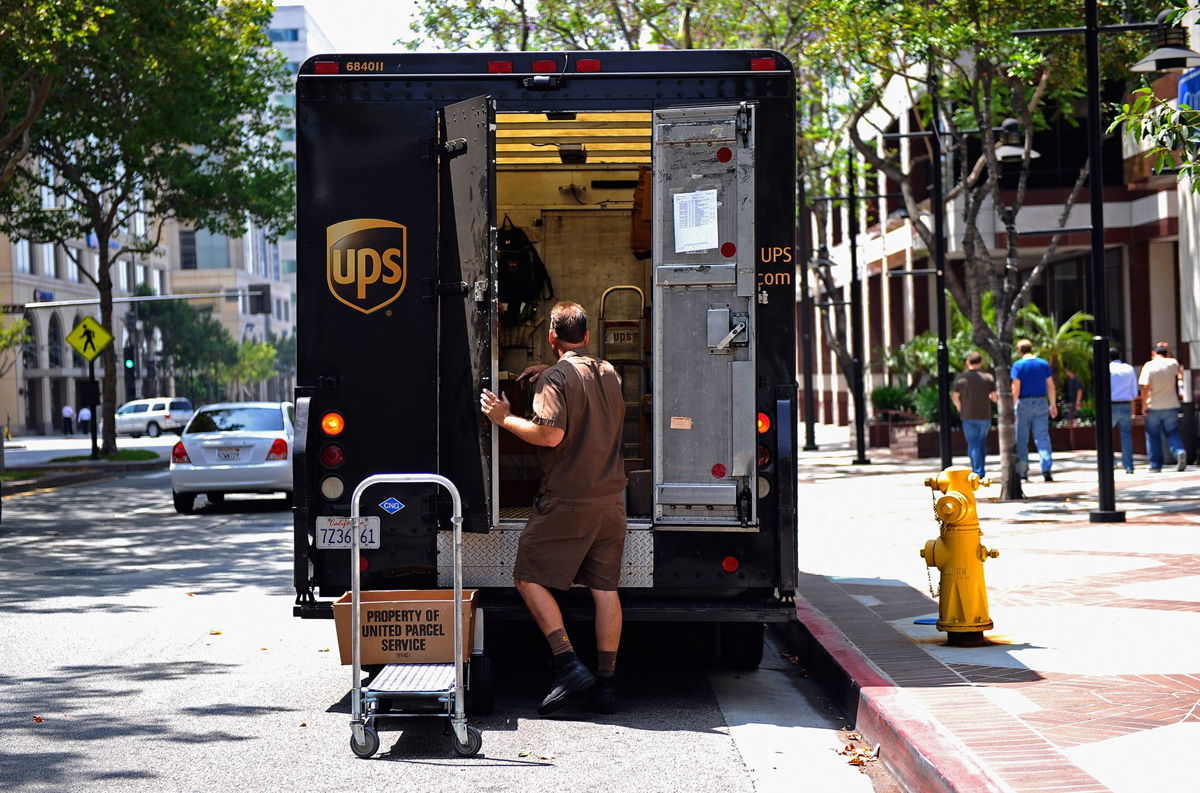 A UPS driver walks back to his truck after making a delivery in Glendale, California. UPS reported sharply lower earnings in the third quarter.