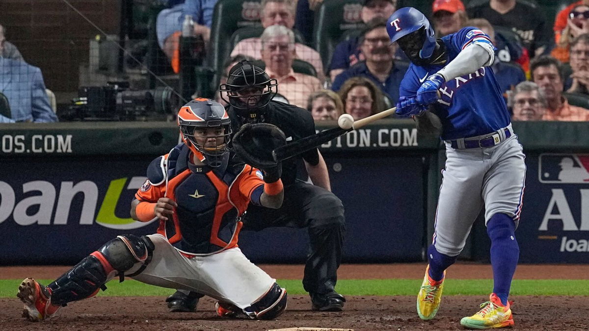 <i>Tony Gutierrez/AP</i><br/>Texas Rangers' Adolis García hits a grand slam during the ninth inning of Game 6.