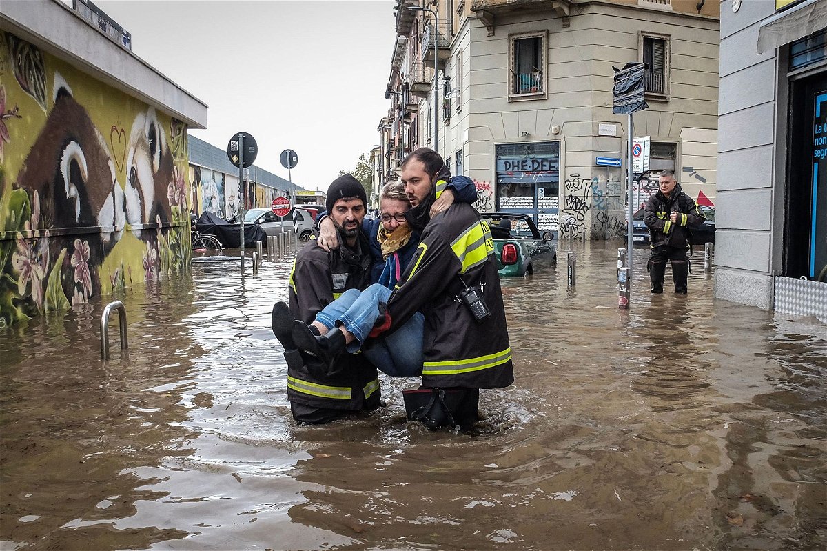 <i>Vasile Mihai-Antonio/Getty Images</i><br/>Two women at a flooded intersection in Milan after a violent storm hit the city on October 31.
