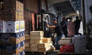 A worker prepares to wheel a pallet of food at a wholesale produce market in the Union Market district in Washington