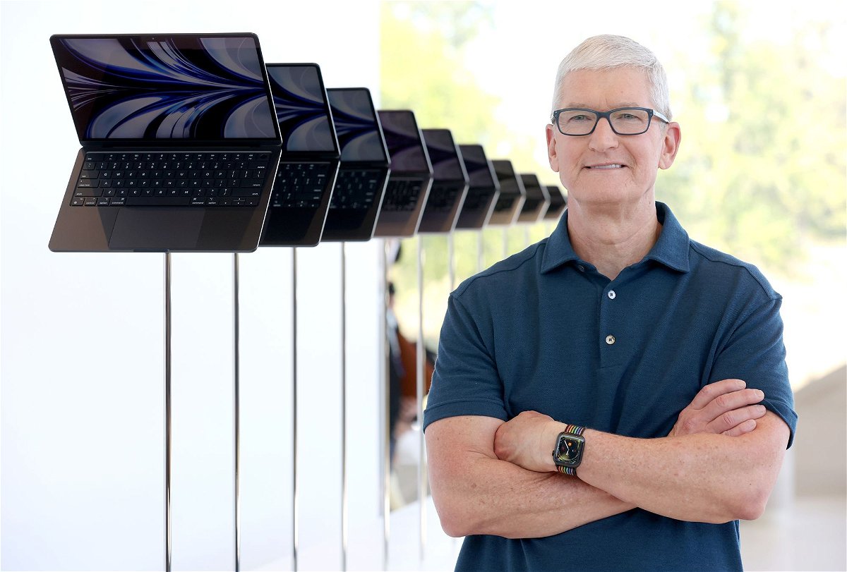 Apple CEO Tim Cook stands next to a display of newly redesigned MacBook Air laptop during the WWDC22 at Apple Park on June 6, 2022 in Cupertino, California.