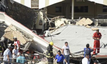 Rescue workers search in the debris for dozens of worshipers missing following the disaster.