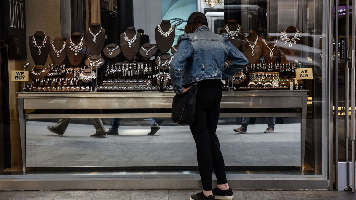 A pedestrian views diamond jewelry in the window of a store in the Diamond District neighborhood of New York.