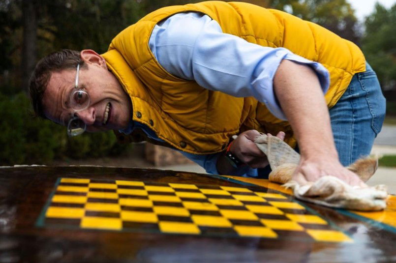 <i></i><br/>Tim Cayford prepares a stump for another coat of varnish on a tree stump at Dundee Elementary on October 25. Cayford put a chessboard on the stump.