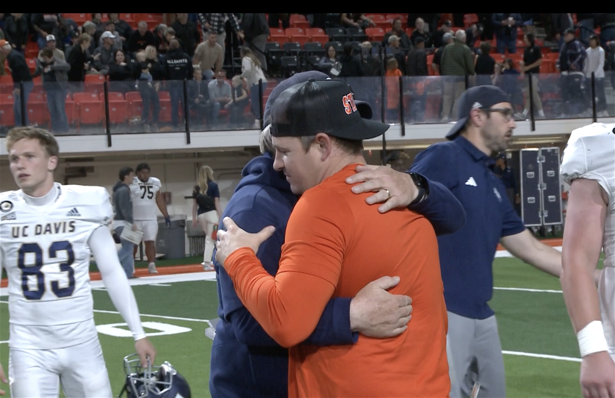 Cody Hawkins and Dan Hawkins embrace after game