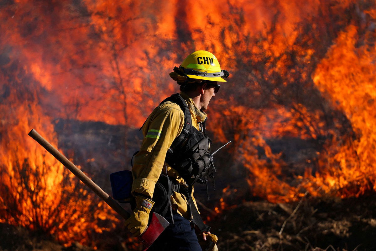 A firefighter works to extinguish the Highland Fire, a wildfire near Aguanga, California, October 31.