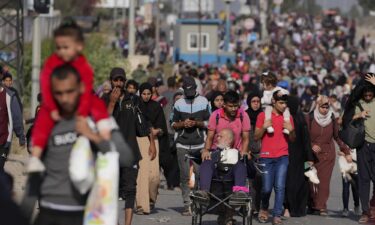 A Palestinian woman carries her passport and ID as she flees south on November 7.