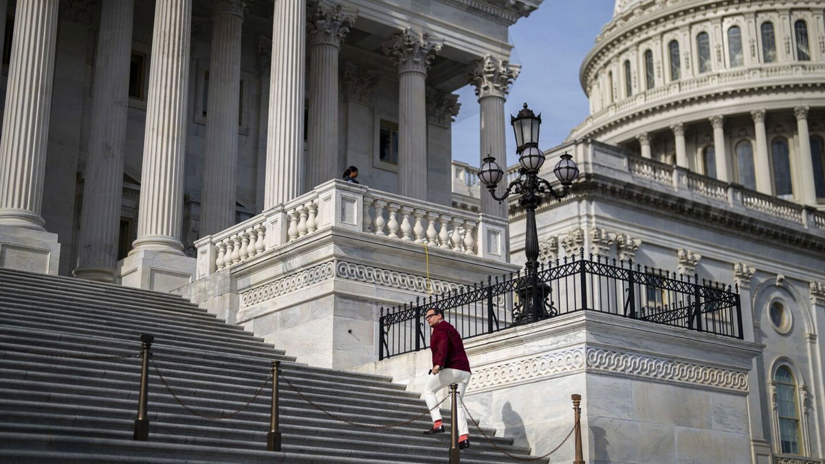 <i>Drew Angerer/Getty Images</i><br/>Rep. George Santos walks back to his office after debate on the House floor on a resolution to expel him from Congress