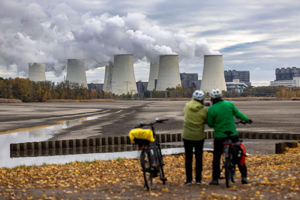 Cyclists look towards cooling towers at the Jaenschwalde lignite coal-fired power plant, in Peitz, Germany, on November 7.