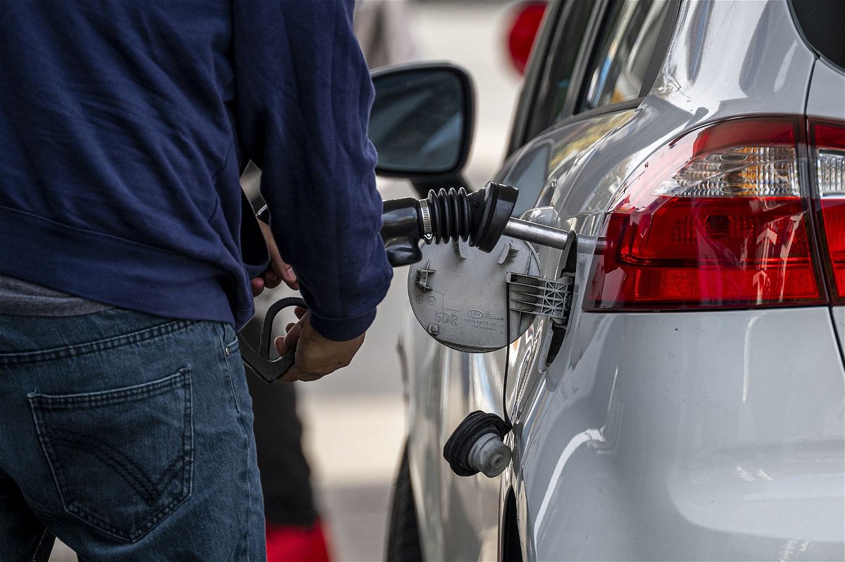 A customer refuels at a Chevron gas station in San Francisco, on November 21. Gas prices have dropped by more than 60 cents since the peak in September, according to AAA.