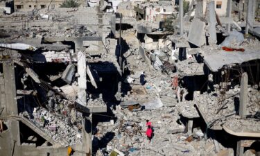 Palestinian children walk among the houses destroyed at Khan Younis refugee camp in the southern Gaza Strip on November 29.